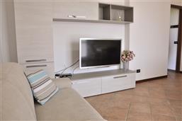Wohnraum mit Sofa und SAT-TV